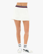 White skirt with striped waistband worn by a person on a white background